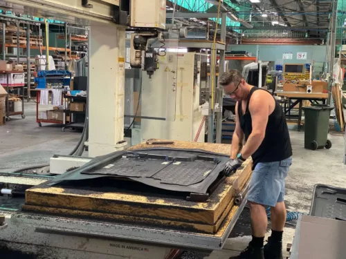 a man working on a piece of metal in a factory.