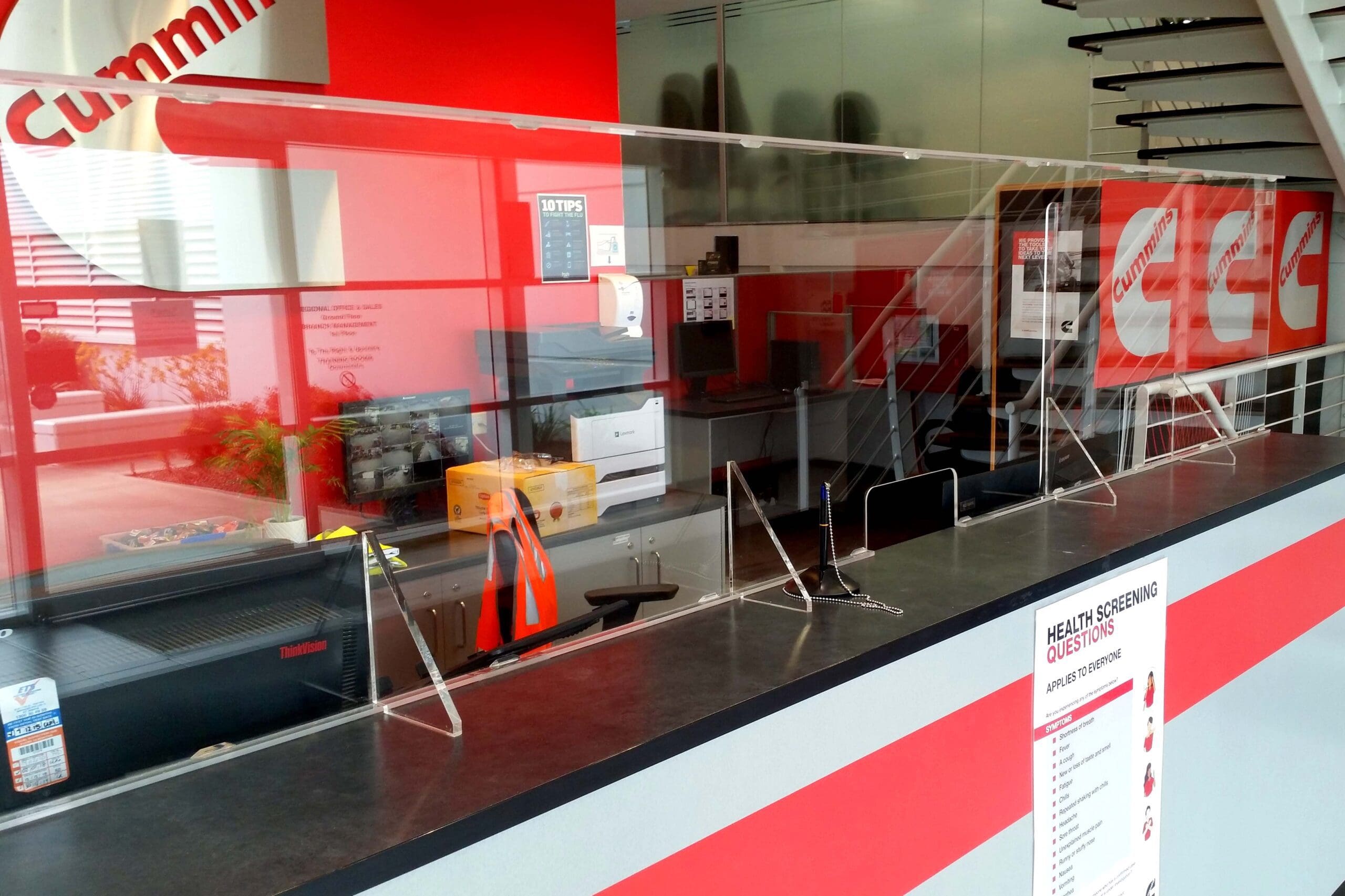 A red and white store front with a large sneeze guard window.